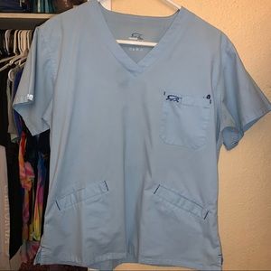 Iguana med Light blue scrub top.